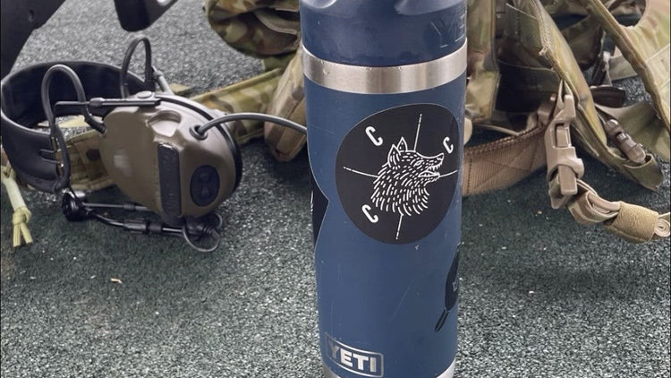 Covert Canine Co sticker on a water bottle next to equipment.