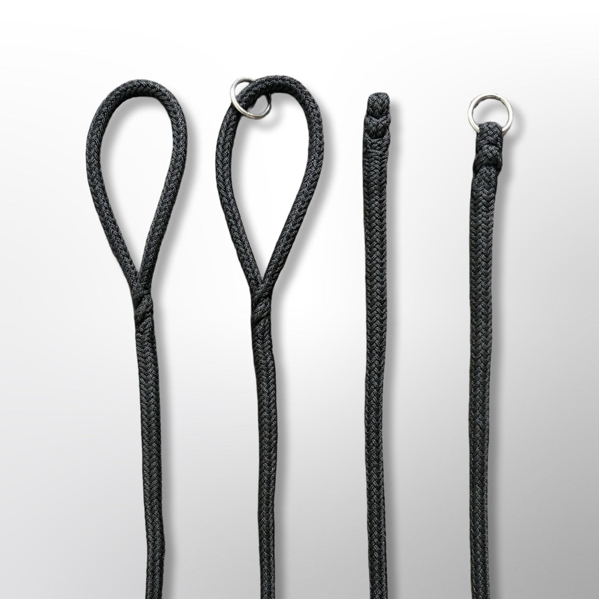 Four handle options on the Covert Canine Co. rope tracking line, left to right: spliced loop handle, loop handle with stainless floating ring, no-handle spliced end, and stainless ring spliced into the end